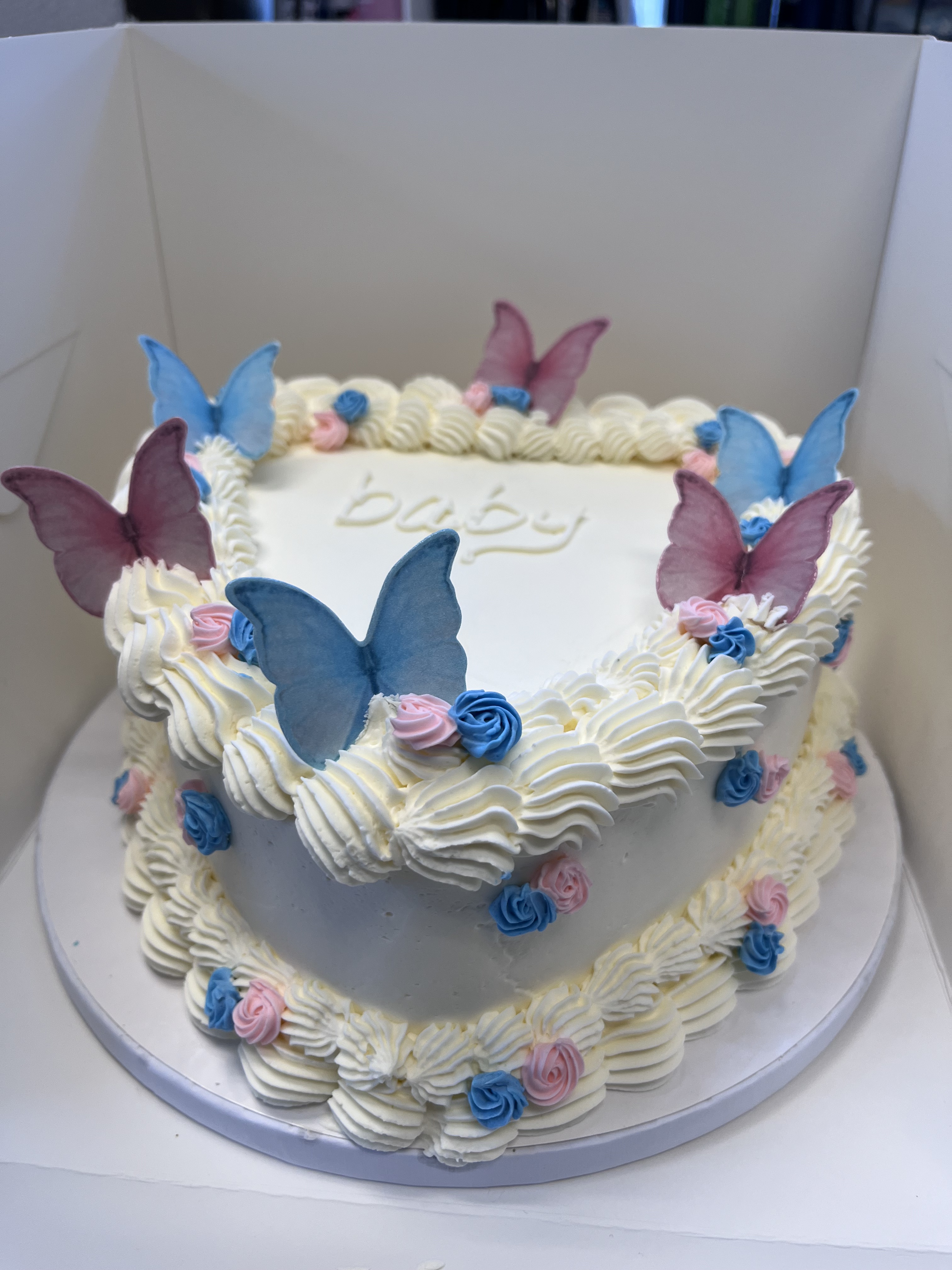 Heart shaped gender reveal cake with edible butterflies